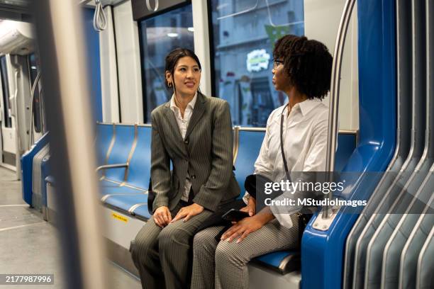 two business women commuting on public transport in the city - public service recognition stock pictures, royalty-free photos & images