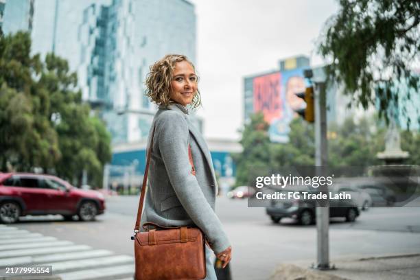 portrait d’une femme d’affaires mature dans une ville mexicaine - regarder par dessus son épaule photos et images de collection