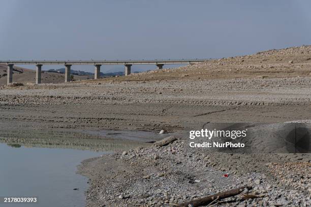 Visible banks, dry soil, and uncultivated vegetation replace the water at Lake Monte Cotugno, a reservoir in Basilicata, which in the summer of 2024...