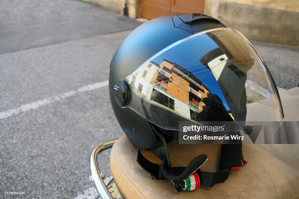 Close-up of motocycle helmet, shield reflecting house