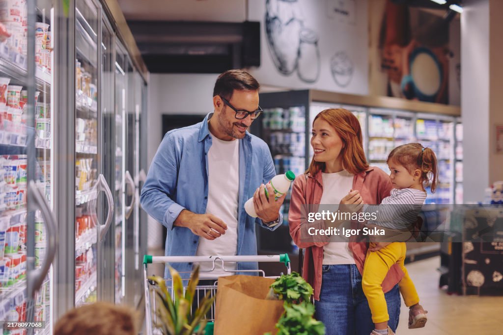 Happy Family Shopping Together in a Supermarket Dairy Aisle