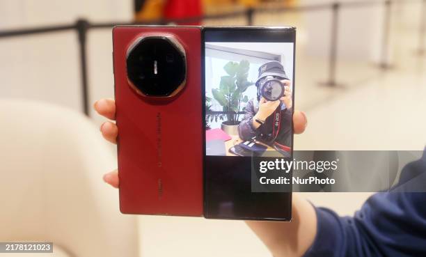Customer experiences the Mate XT, a triple foldable screen phone, at Huawei's global flagship store in Shanghai, China, on October 15, 2024.