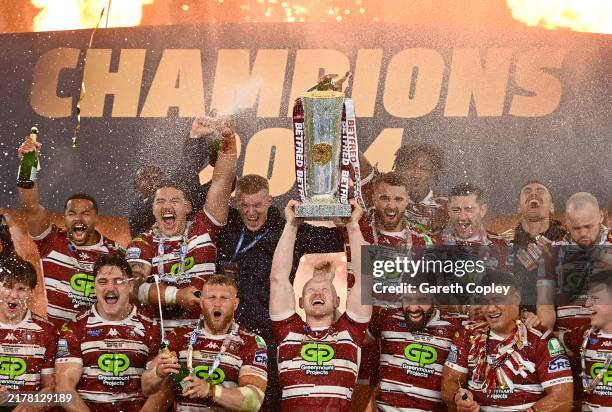 Liam Farrell of Wigan Warriors lifts the Super League Trophy after his team's victory in the Betfred Super League Grand Final between Wigan Warriors...