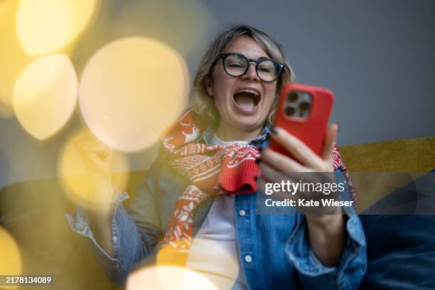 emotional mature woman celebrating win in online lottery prize or virtual giveaway - giveaway stock pictures, royalty-free photos & images