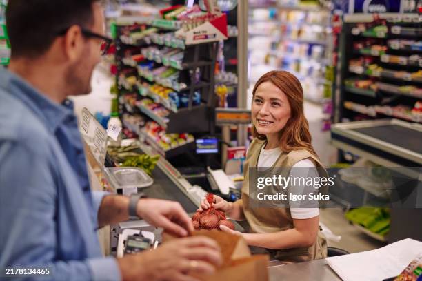 friendly customer and cashier interaction in a supermarket checkout - self checkout line stock pictures, royalty-free photos & images
