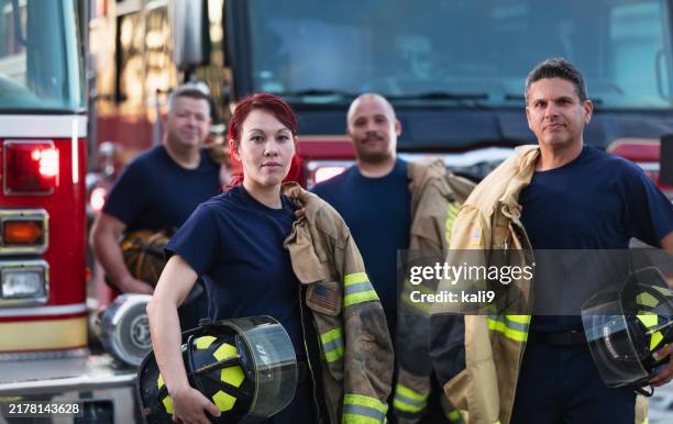 female firefighter and group of firemen with fire trucks - rescue services occupation stock pictures, royalty-free photos & images