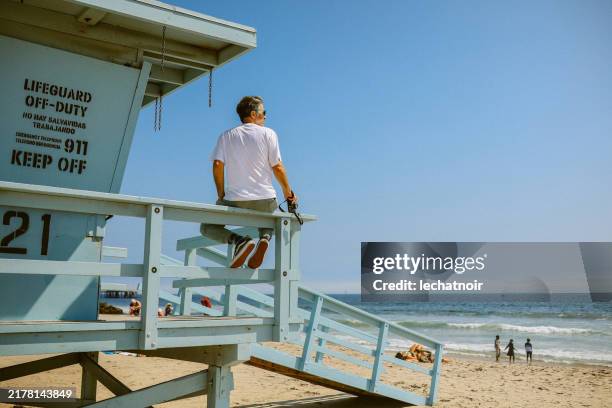 fotografo maschio che si rilassa sulla spiaggia di venezia, ca - los angeles foto e immagini stock