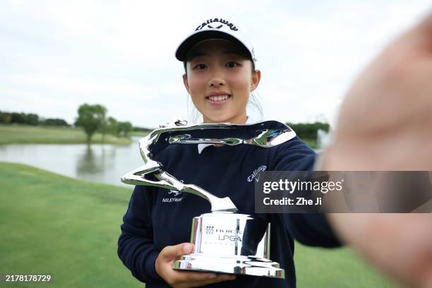 Ruoning Yin of China imitates a “selfie” as she poses with the trophy after winning the final round of the Buick LPGA Shanghai 2024 at Qizhong Garden...