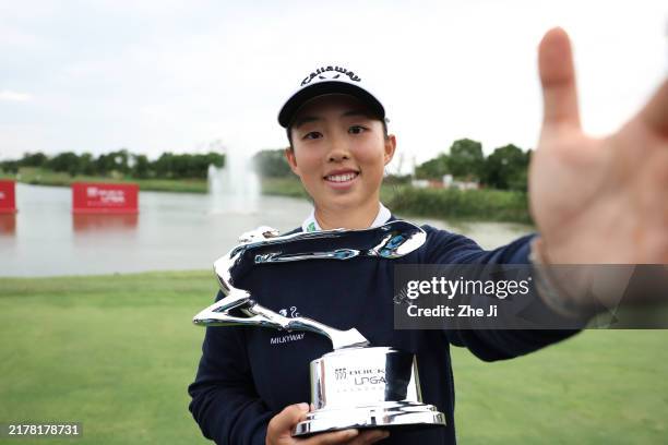Ruoning Yin of China imitates a “selfie” as she poses with the trophy after winning the final round of the Buick LPGA Shanghai 2024 at Qizhong Garden...
