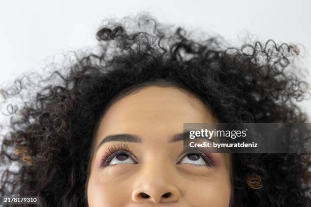 mujer de pelo rizado mirando hacia arriba - levantar las cejas fotografías e imágenes de stock
