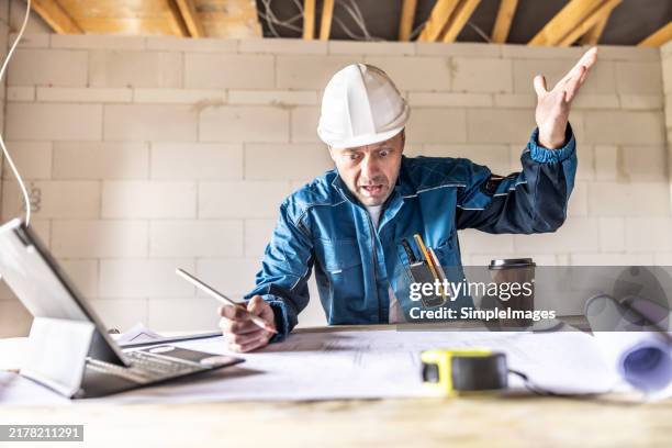 the terrified construction manager gets upset over the meaningless dimensions on the technical drawing. - construction mistake stock pictures, royalty-free photos & images