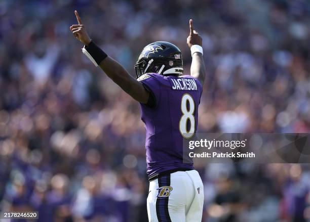 Lamar Jackson of the Baltimore Ravens celebrates after teammate Derrick Henry scores a touchdown against the Washington Commanders during the second...
