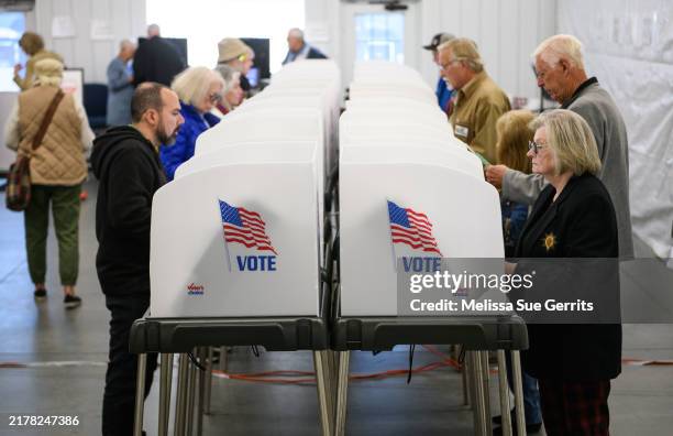 Voters make selections at their voting booths inside an early voting site on October 17, 2024 in Hendersonville, North Carolina. Several counties...