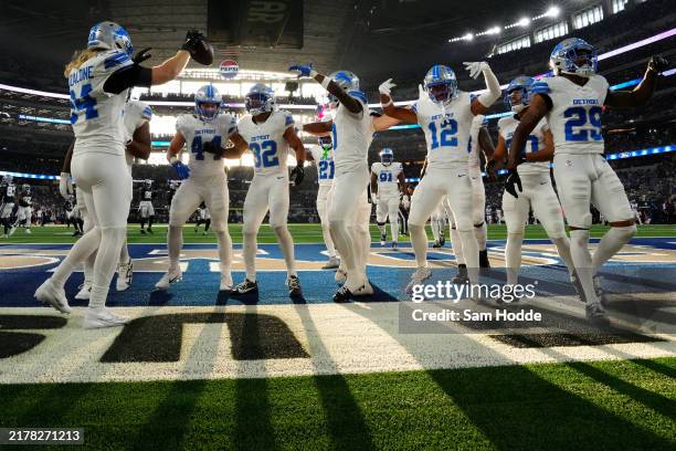 Brian Branch of the Detroit Lions celebrates with teammates after an interception in the fourth quarter of a game against the Dallas Cowboys at AT&T...