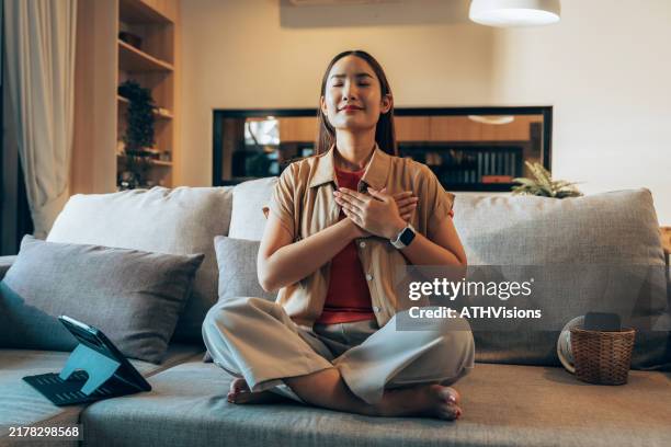 gen z woman meditating on couch during digital detox - self love stock pictures, royalty-free photos & images