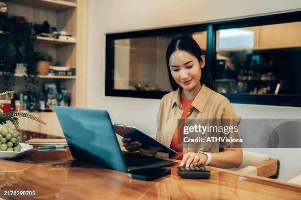 focused young woman working remotely on laptop in minimalist workspace - personalization stock pictures, royalty-free photos & images