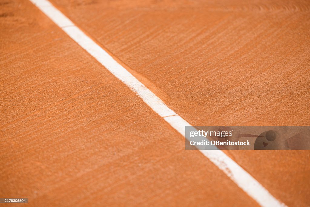 Clay tennis court focusing on one of the lines. Sport, competition, championship, exercise.