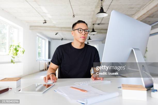 hübscher asiatischer mann, der am kreativen arbeitsplatz arbeitet - grafiker stock-fotos und bilder