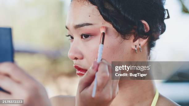 close-up view of beautiful young woman applying eyeshadow with brush - oogschaduw stockfoto's en -beelden