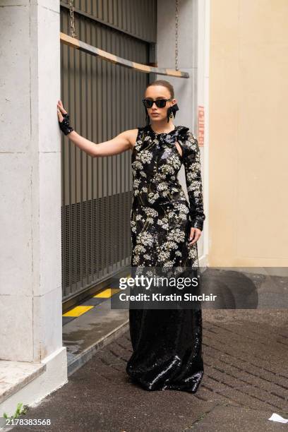 Maria Braz wears a Giambattista Valli dress and fingerless gloves, Burberry earrings and Ray Ban sunglasses outside the Giambattista Valli show...