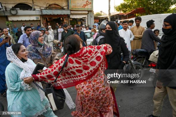 Police personnel detain Pakistan Tehreek-e-Insaf party's supporters whilst they protest to demand the release of former prime minister Imran Khan, in...