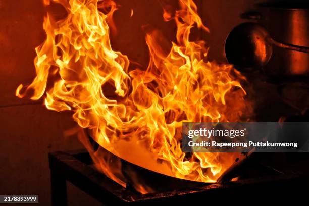 the wok in fire during frying green vegetable in kitchen. - wok stockfoto's en -beelden