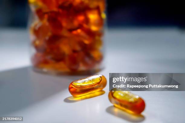 omega 3 pills and white medicine bottles on the table. healthy supplement pills. - cod liver oil stock pictures, royalty-free photos & images