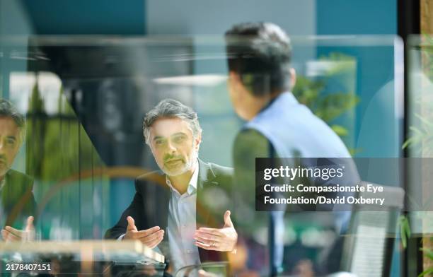 medium shot of businessman discussing project with colleague - administrador fotografías e imágenes de stock