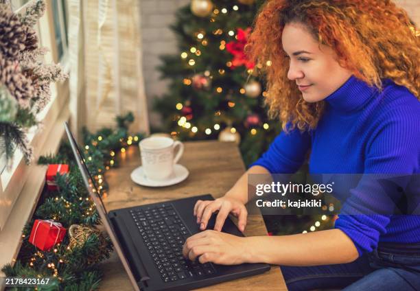 young beautiful woman working at home for the christmas holidays - business finance and industry stock pictures, royalty-free photos & images