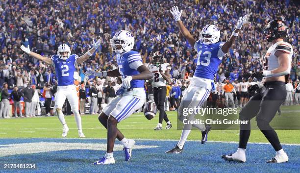Chase Roberts and Jojo Phillips of the Brigham Young Cougars celebrate as teammate Darius Lassiter of the carries the ball into the endzone for the...