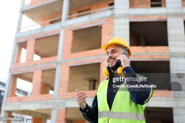 construction worker talking on a phone - construction worker smiling stock pictures, royalty-free photos & images