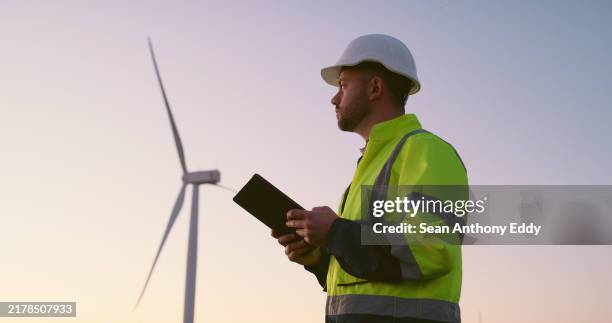 engineer, man and tablet with windmill outdoor for generator maintenance, inspection and electricity safety. male person, digital and sustainable for renewable energy, power project and wind turbine - real estate developer stock pictures, royalty-free photos & images