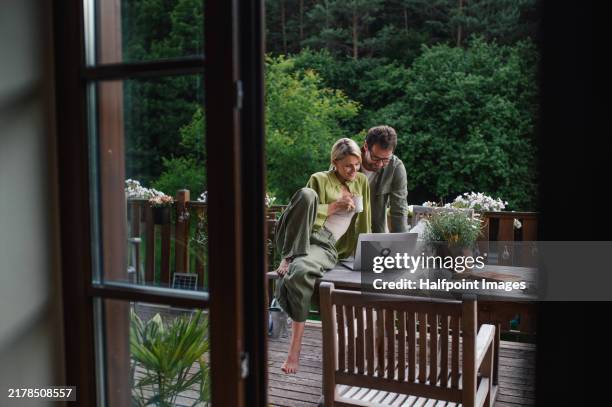 beautiful wife looking at laptop screen of her husband. couple shopping together, looking for vacation. - prévision photos et images de collection