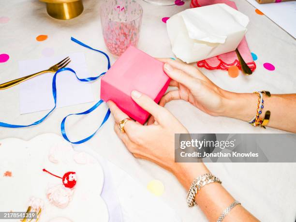 woman opening pink gift box at birthday party - wrapped stock pictures, royalty-free photos & images