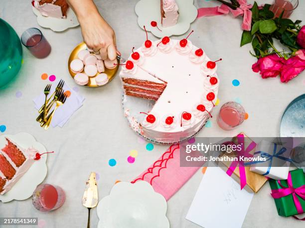 hand slicing pink cherry birthday cake at birthday party - birthday cake stock pictures, royalty-free photos & images