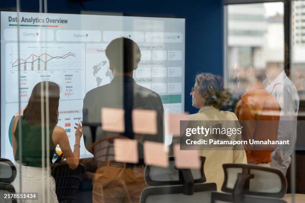 diverse business development team brainstorming new products and services using a digital display during a business meeting. business intelligence and data-driven decisions empowering strategy, growth, and resilience in a modern office. - risicomanagement stockfoto's en -beelden