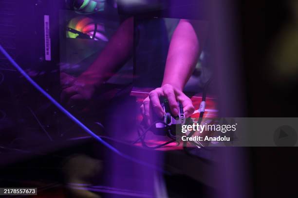 Visitor holds a computer mouse as he plays a video game during Thailand Game Show at Queen Sirikit National Convention Center in Bangkok, Thailand on...