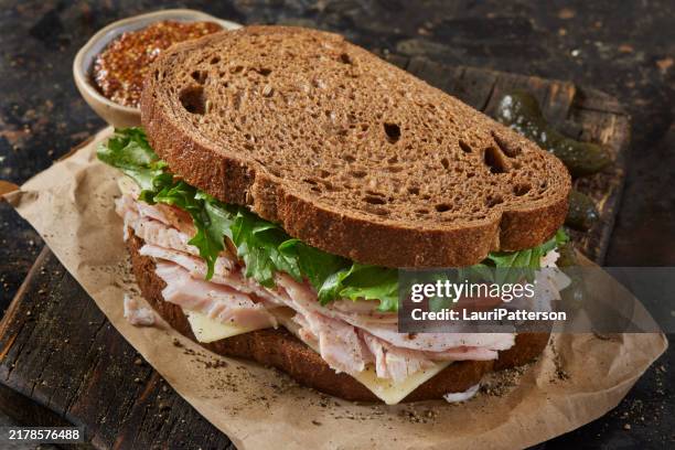 left over roast turkey and swiss sandwich - brown bread stock pictures, royalty-free photos & images