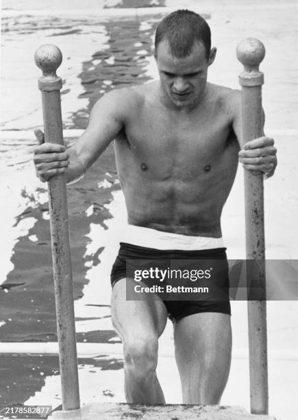 Jeff Farrell, Wichita, KS, with his stomach heavily bandaged with white tape, emerges from pool after winning a 100-meter freestyle heat of U.S....