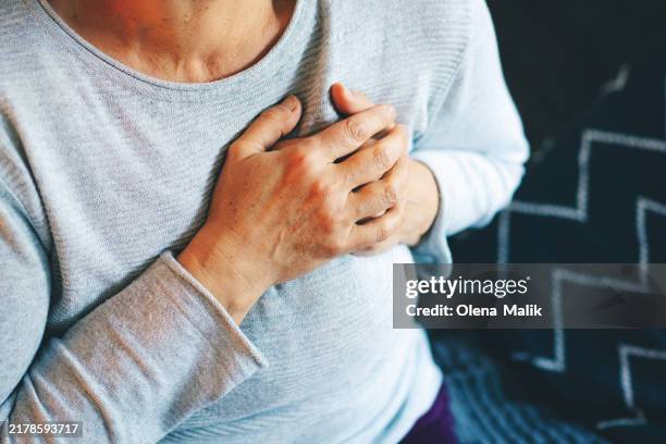 senior woman experiencing chest discomfort - heart pain stock pictures, royalty-free photos & images