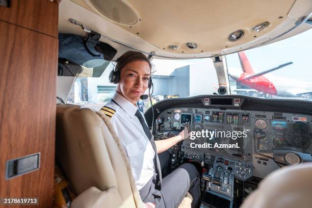 piloto profesional asiático se prepara para volar en cabina - pilotar fotografías e imágenes de stock