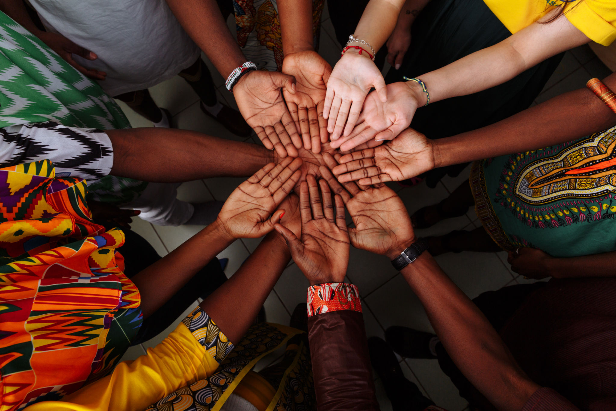 Palms up hands of a group of multinational people: African, Latin American and European people which stay together in a circle Palms up hands of a group of multinational people: African, Latin American and European people which stay together in a circle