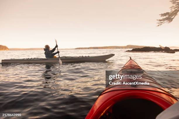 hombre navegando en kayak al amanecer - deporte acuático fotografías e imágenes de stock