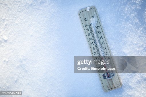 The thermometer on the snow shows low temperatures well below zero. Extreme winter freezing weather. The thermometer on the snow shows low temperatures well below zero. Extreme winter freezing weather.