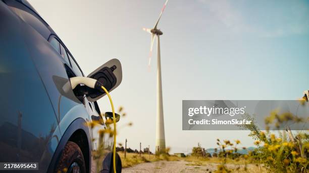 carga de vehículos eléctricos con energía eólica - suministro de energía fotografías e imágenes de stock