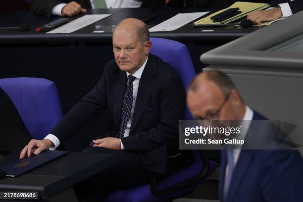 German Chancellor Olaf Scholz looks on as Friedrich Merz, leader of the German Christian Democrats , speaks after Scholz gave a government...