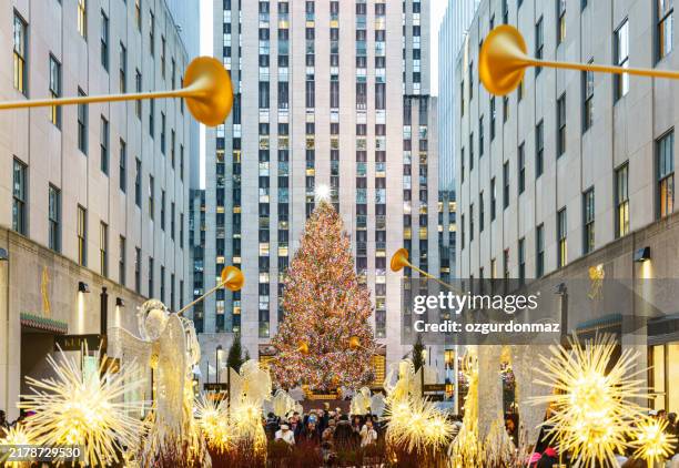 christmas tree, christmas decorations with angels and large group of people at rockefeller centre new york - rockefeller center stockfoto's en -beelden
