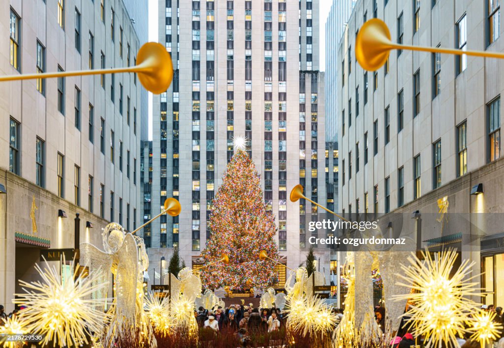 Christmas tree, Christmas decorations with angels and large group of people at Rockefeller Centre New York