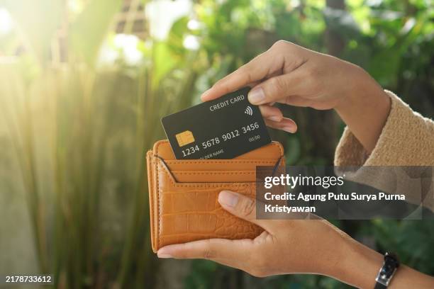 black credit card put in wallet - portefeuille stockfoto's en -beelden