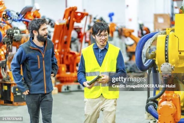 team of engineers inspecting the machine in a robotic arm production line - automatization stock pictures, royalty-free photos & images